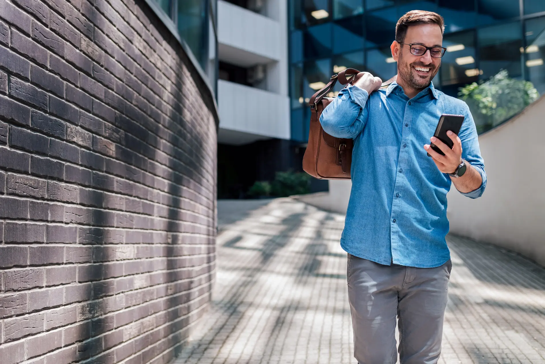 Mann auf dem Weg in die Arbeit postet etwas auf seinem Smartphone