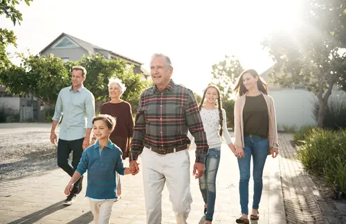 Mehrere Generationen zu Fuß unterwegs, es scheint die Sonne im Hintergrund